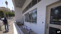 Čovjek provjerava oštećenja na američkoj ambasadi poslije provladinih demonstracija kada je napadnuta ambasada u Damasku, 11. jul 2011.