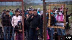 Migranți și refugiați așteptând să se înregistreze la o tabără din Macedonia, după ce au traversat hotarul Greciei, 22 septembrie 2015