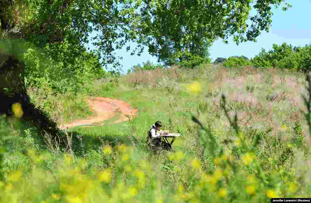 Джулио Джованнини знакомится учебным материалом, смотря на экран планшета. Школьник забрался на вершину холма недалеко от его родного города Скансано, в центральной части Италии, чтобы воспользоваться надежным 3G-интернетом для доступа к онлайн-урокам. 