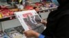 A woman browses the front page of the Iranian newspaper Sharq featuring the 2020 U.S. election results at a newsstand in Tehran on November 8, 2020.