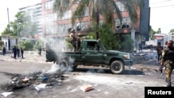 Soldații congolezi ajung la clădirea ambasadei Rwandei, jefuită de protestatarii din Kinshasa.