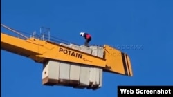 Tajik migrant on crane 