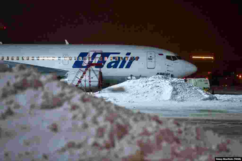 Самолет авиакомпании Utair в аэропорту Внуково во время снегопада.