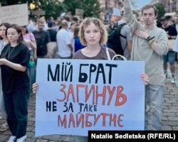 A protester in Kyiv on July 22 holds a sign that reads, "This is not the future my brother died for."