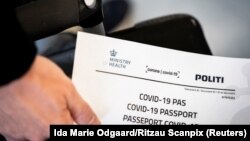Një person në Danimarkë mban në duar një certifikatë të vaksinimit kundër COVID-19. Fotografi nga arkivi. 