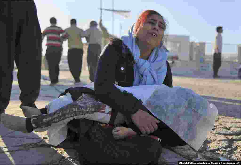 A woman mourns as she holds the body of her daughter in Sarpol-e Zahab.