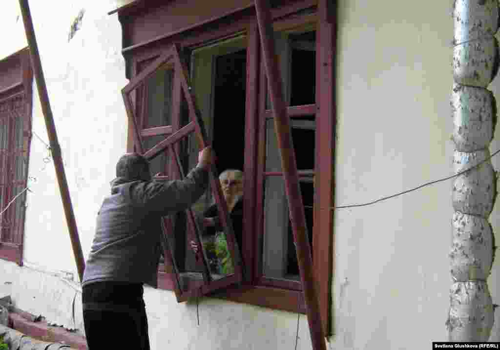 Жильцы пытаются вставить оконную раму, которую вынесло ударом взрывной волны. Астана, 24 мая 2011 года. - Жильцы дома пытаются вставить оконную раму, которую вынесло ударом взрывной волны. Астана, 24 мая 2011 года