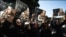 Women hold pictures of Iranian poet Simin Behbahani at her funeral in Tehran on August 22.