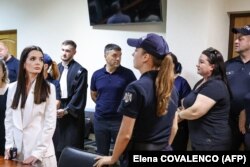 Проросійський башкан ( очільниця Виконавчого комітету) автономного регіону Гагаузія Молдови Євгенія Гуцул (ліворуч у білому костюмі) у залі суду. Її засудили до 7 років ув'язнення. Кишинів, Молдова. 5 серпня 2025 року