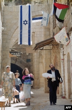 نسخهٔ کامل عکس بالای متن: یک خانواده یهودی در حال عبور از کوچه‌ای در شهر قدیمی اورشلیم، ۱۵ سپتامبر ۱۹۹۳