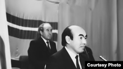 Жогорку Кеңеште Кыргызстандын туңгуч президенти болуп шайланган академик Аскар Акаевдин артында Кыргызстан КП БК Биринчи катчысы, Жогорку Кеңештин төрагасы Абсамат Масалиев турат. 27.10.1990. (КДКнын "Майдан" гезитинен).