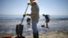 Voluntari curăță de petrol o plajă din California