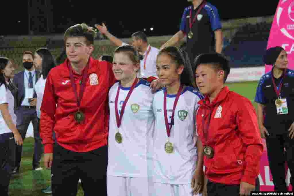 Кыргызстандык футболчу кыздар өзбекстандык атаандаштары менен.&nbsp;