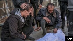 Palestinieni la spitalul Al-Shifa din Gaza care plâng victime ale incidentului care a ucis peste 100 de persoane