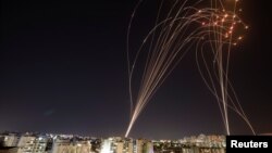 Светлосните ленти се гледаат откако израелскиот антиракетен систем „Iron Dome“ пресретна ракети лансирани од Појасот Газа кон Израел, како што се гледа од Ашкелон, Израел. 11 мај 2021 година.