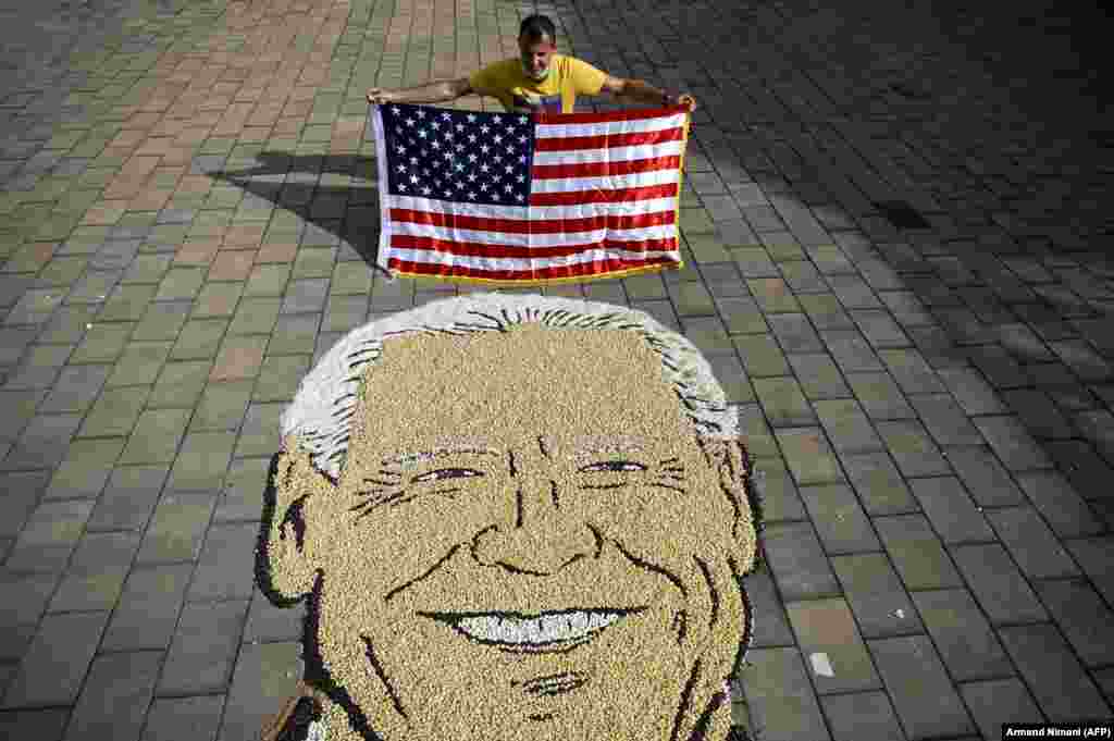 Egy koszovói művész,&nbsp;Alkent Pozhegu egy Joe Bident ábrázoló utcai festmény utolsó simításain dolgozik.