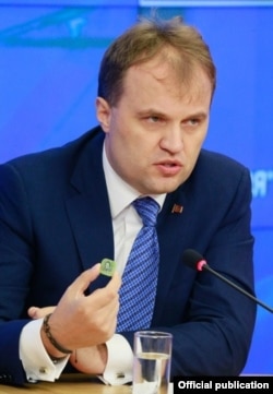 Evgheni Şevciuk la Moscova, demonstrând noile ruble transnistrene de plastic, 2 octombrie 2014