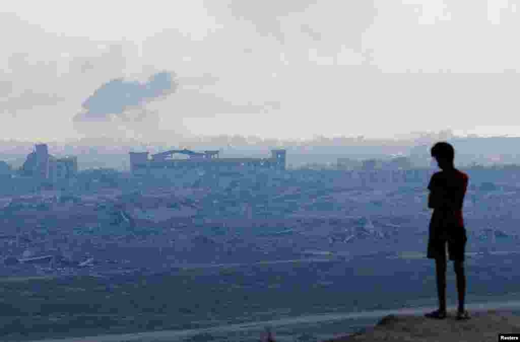 Палестинский мальчик смотрит на дым, поднимающийся во время израильской военной операции в городе Газа, 1 октября 2025 года. REUTERS/Mahmoud Issa