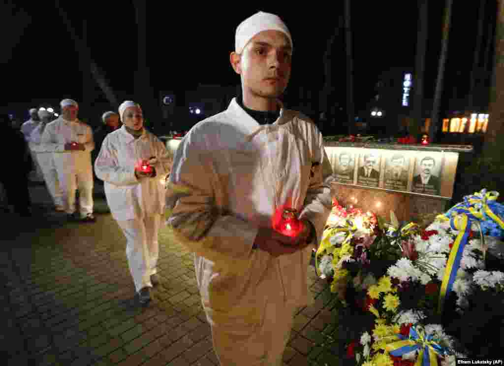 Працівники ЧАЕС в уніформі під час церемонії вшанування пам&rsquo;яті жертв аварії біля меморіалу загиблим пожежникам та ліквідаторам аварії на ЧАЕС. Славутич, 26 квітня 2019 року. &nbsp;