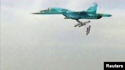 A still image taken from video footage and released by Russia's Defence Ministry on August 18 shows a Russian Sukhoi Su-34 fighter bomber based at Iran's Hamadan air base dropping bombs in the Syrian province of Deir ez-Zor.