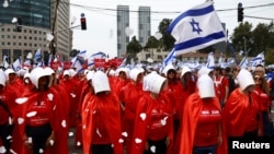 Manifestanți îmbrăcați în personaje din serialul „Povestea slujitoarei”, la un protest față de modificările din legislația juridică propuse de guvernul de coaliție al premierului Benjamin Netanyahu. Tel Aviv, Israel, 23 martie 2023.