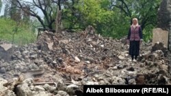 Жительница селе Кок-Терек в Баткенской области на месте разрушенного в результате конфликта дома.