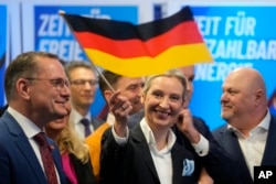 A szélsőjobboldali AfD vezetője, Alice Weidel német zászlót lenget a párt berlini székházánál 2025. február 23-án, vasárnap a német szövetségi választások után.