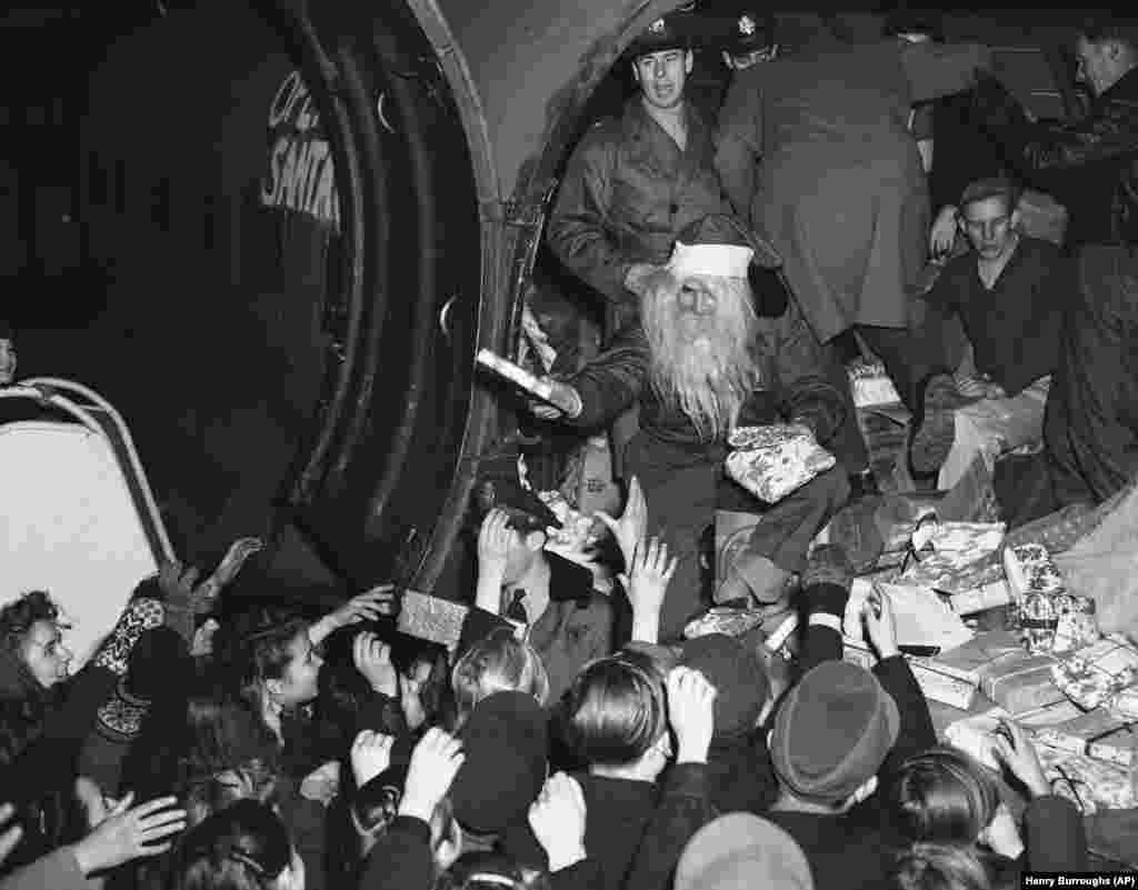 Copiii berlinezi au parte de o surpriză pe aeroportul Tempelhof din Berlin, pe 15 decembrie 1948: Cadouri de Crăciun de la un Moș Crăciun zburător, cunoscut și ca locotenentul John Konop din Astoria, New York. Acesta a fost primul transport aerian de la donatori americani care a fost distribuit în cadrul programului Forțelor Aeriene ale SUA cunoscut sub numele de Operațiunea Moș Crăciun.