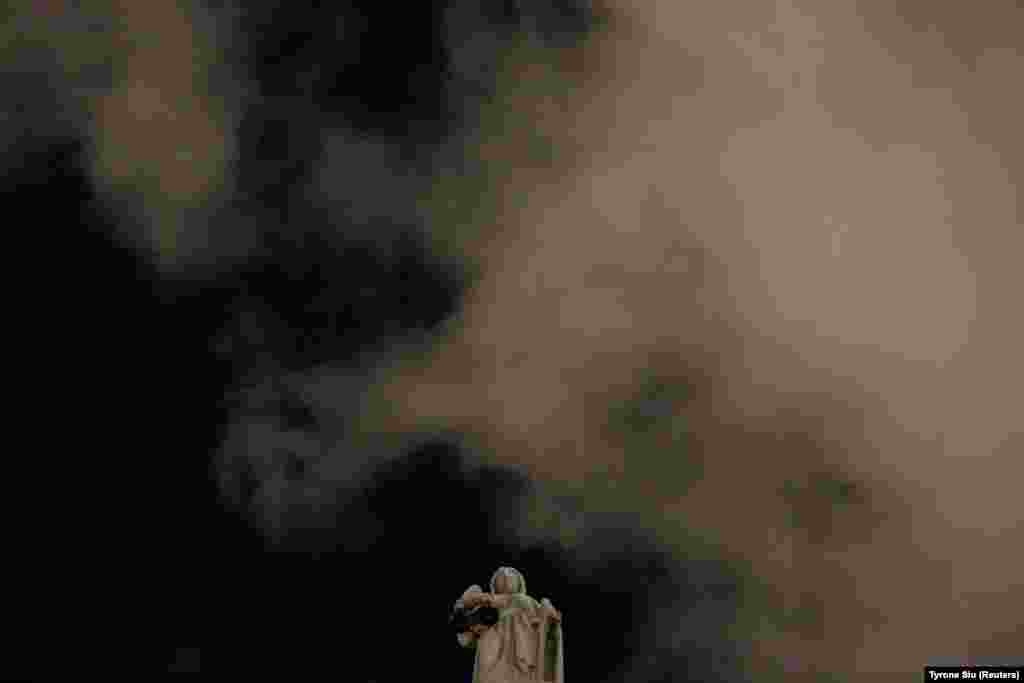 Дим над постаментом Феміди біля Суду останньої інстанції у Гонконгу під час мовчазного протесту