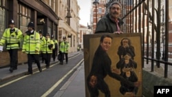 Чоловік стоїть поруч з картиною, що зображає прем'єр-міністра Великобританії Девіда Кемерона, Лондон, поряд з будівлею Верховного суду, 14 червня 2012 року