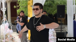 ადამ კადიროვი თავის ქორწილში ოქროს პისტოლეტით და საათით, რომლის ორიგინალი შვიდი მილიონი დოლარი ღირს.