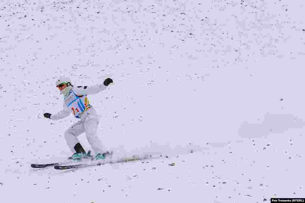 Лыжница приземляется после удачного прыжка.