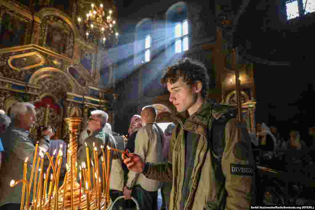 Відвідувачі богослужіння ставлять свічки у монастирі