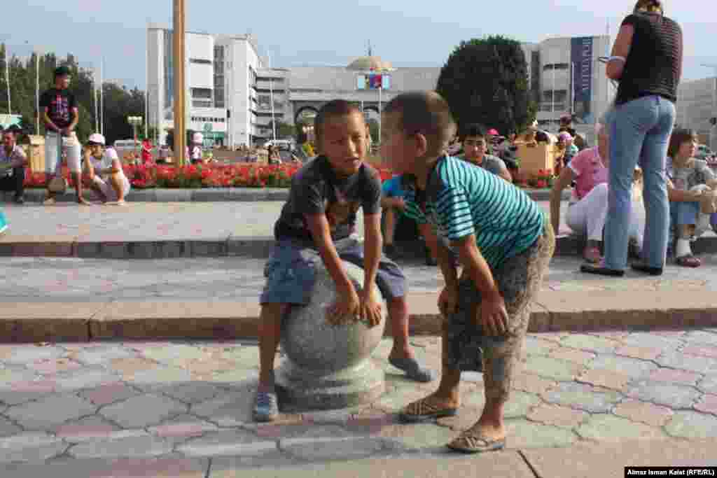 Мальчишки, торгующие на площади игрушками и прохладительными напитками, с интересом наблюдают за репетицией. 