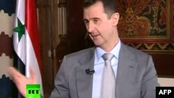 Башар аль-Асад, кард із його попередньої появи на телебаченні в інтерв’ю російському телеканалові RT, 8 листопада 2012 року