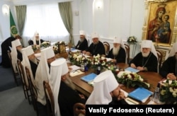 Під час засідання синоду РПЦ, на якому було ухвалене рішення розірвати церковне спілкування зі Вселенським патріархатом. По ліву руку від патріарха РПЦ Кирила (Гундяєва) сидить очільник УПЦ (Московського патріархату) Онуфрій (Березовський). Мінськ, 15 жовтня 2018 року