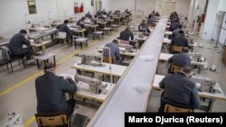 Колония в Сербии. В тюремном цеху заключенные шьют защитные маски для собственных нужд. Все работающие в масках и соблюдают дистанцию