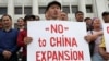 Участники акции в поддержку жанаозенцев, которые требуют прекратить реализацию в Казахстане китайских проектов. Мужчина в Алматы держит плакат с надписью: «Нет китайской экспансии». 4 сентября 2019 года.