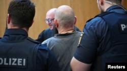 Inculpatul Dieter S. este escortat la tribunal, în München, Germania, 20 mai 2025