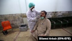 A health official conducts a COVID-19 test on a journalist in Peshawar on June 3.