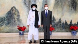 Cofondatorul talibanilor Mullah Abdul Ghani Baradar (stânga) și ministrul chinez de externe Wang Yi pozează în timpul întâlnirii lor de la Tianjin/China din 28 iulie 2021.