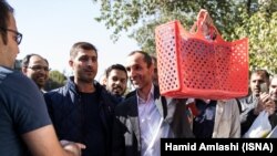 حمید بقایی معاون احمدی نژاد در جریان حضور خود در دادگاه از زنبیلی قرمز برای حمل وسایل خود استفاده می کند. 