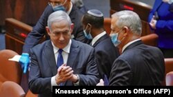 Izraelski premijer Benjamin Netanyahu (L) i zamjenik premijera Benny Gantz razgovaraju tokom ceremonije polaganja zakletve nove vlade u Jeruzalemu, 17. maja 2020.