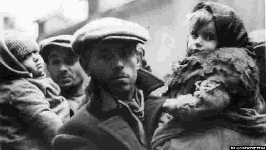 Жители на Варшавското гето държат децата си. Снимка: Дж. Дж. Хайдекер