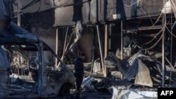 Орус армиясынын чабуулунан улам кыйрап калган имараттын урандыларынын арасында турган жергиликтүү тургун. Одесса. 8-март, 2025-жыл. 