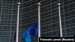 An European Union flag flies outside the EU Commission headquarters in Brussels.