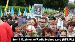 Чоловік із портретом головного командира УПА Романа Шухевича вирішив також пройтися разом із учасниками акції «Безсмертний полк». На нього не звертали уваги, допоки він не почав вигукувати гасло «Слава Україні!». Київ, 9 травня 2018 року