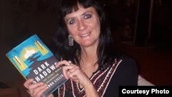 Джоанна Лиллис Қазақстан туралы кітабы "Қара көлеңкені" ұстап тұр.