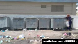 Женщина перебирает в мусорном контейнере. Ашхабад (архивное фото)