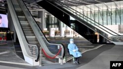 Служител на здравните власти в Хонконг е застанал на входа на банка, поставена под карантина. 17 март 2021 г.